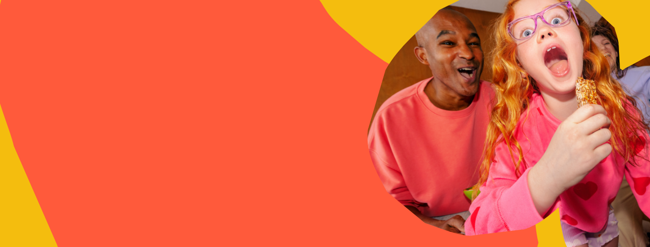 Child with red hair and pink glasses holding a MadeGood granola bar against a colorful background abstract background Child with red hair and pink glasses holding a MadeGood granola bar against a colorful background abstract background