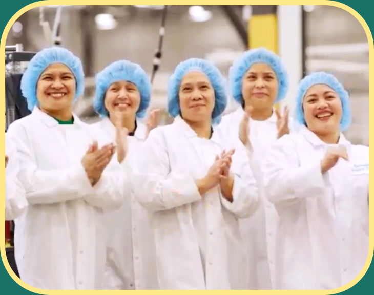 group of production workers in lab coat and hair nets
