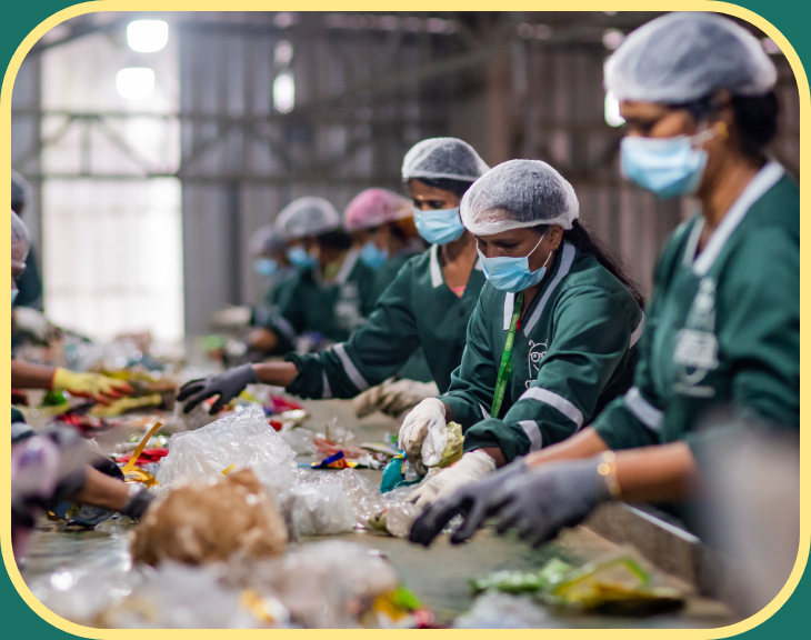 workers in PPE sorting through waste on conveyor belt