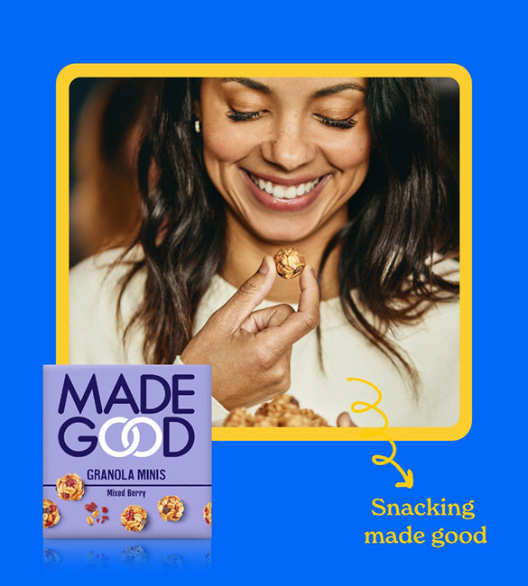 a box of MadeGood granola minis and woman happily snacking
