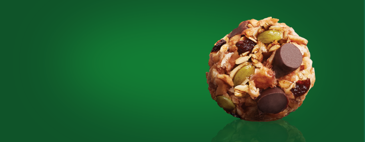 Une bouchée de mélange de noix MadeGood avec des pépites de chocolat, des graines de citrouille, des raisins secs, des canneberges séchées et du beurre de graines de tournesol